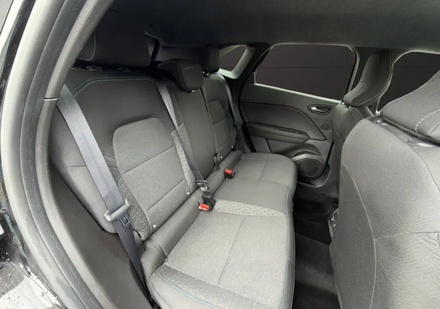 Vue intérieure côté droit sur la banquette arrière noire du Renault SYMBIOZ 2025 avec ceintures et appuie-têtes intégrés.