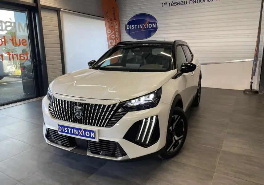 Peugeot 2008 blanc en 3/4 avant droit, calandre noire à lames verticales et feux LED avec griffes distinctives.