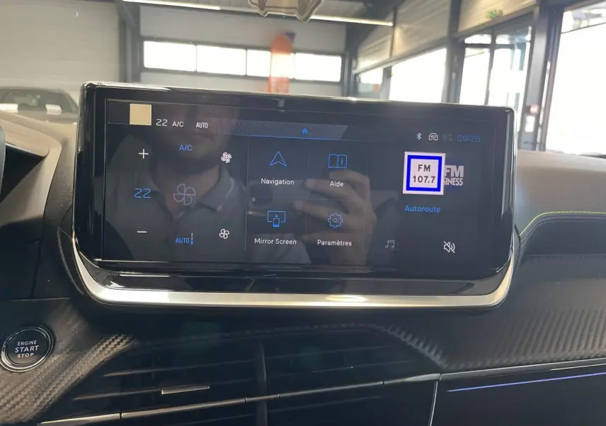 Écran tactile central du tableau de bord du Peugeot 2008 Hybrid avec commandes climatisation et navigation visibles.