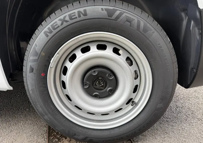 Gros plan sur la roue avant droite du Peugeot Partner blanc Icy, mettant en valeur la jante acier et le pneu Nexen.