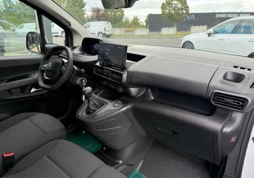 Vue intérieure côté conducteur du Peugeot Partner 2026 blanc Icy, montrant tableau de bord moderne et boîte manuelle.