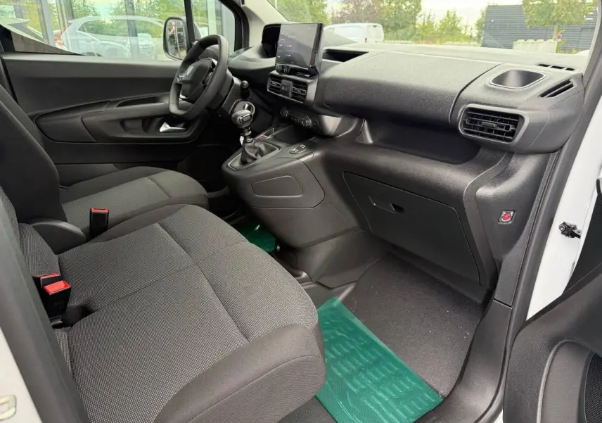 Intérieur avant droit du Peugeot Partner blanc Icy 2026, avec sièges tissu Curitiba et tableau de bord noir moderne.