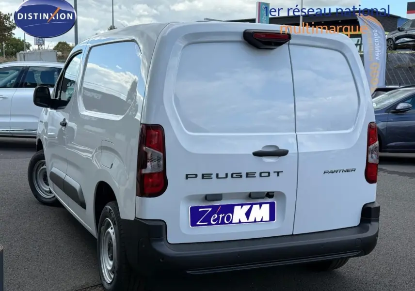 Vue 3/4 arrière droite du Peugeot Partner blanc Icy avec portes arrière battantes et pare-chocs noir.