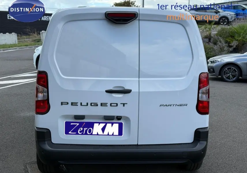 Vue arrière du Peugeot Partner blanc Icy 2026 avec portes battantes et feux arrière rouges distinctifs.