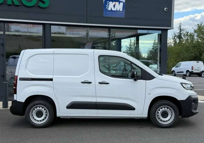 Peugeot Partner blanc Icy vu de profil côté droit, avec porte latérale coulissante et protections noires.