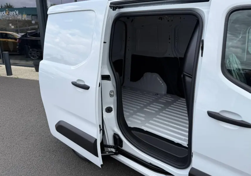 Vue côté droit en gros plan du Peugeot Partner blanc Icy avec porte latérale coulissante ouverte dévoilant l’espace de chargement vide.