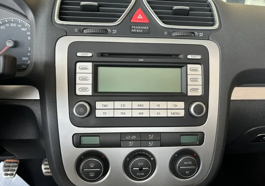 Tableau de bord central d'une Volkswagen EOS 2008 avec commandes radio, climatisation automatique et affichage digital.