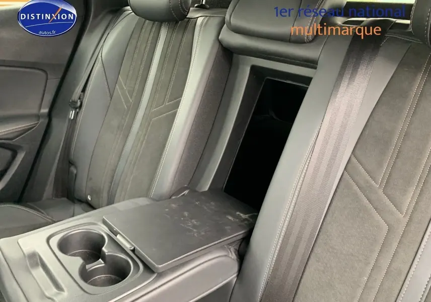 Vue rapprochée de la banquette arrière en cuir noir du Peugeot 3008 gris platinium, avec accoudoir central et porte-gobelets ouverts.