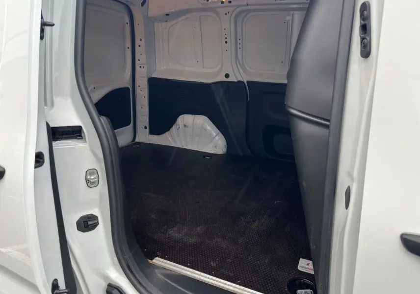 Vue intérieure de la zone de chargement du Peugeot Partner blanc 2022, montrant l'espace vide côté droit avec plancher noir antidérapant.