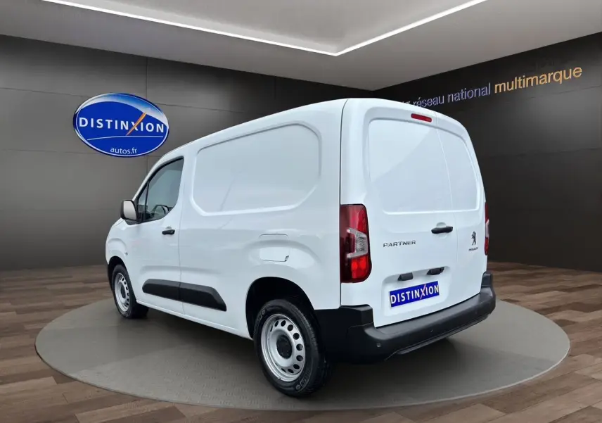 Vue 3/4 arrière droite d'un utilitaire Peugeot Partner blanc 2022 avec logo et plaque Distinxion visibles.