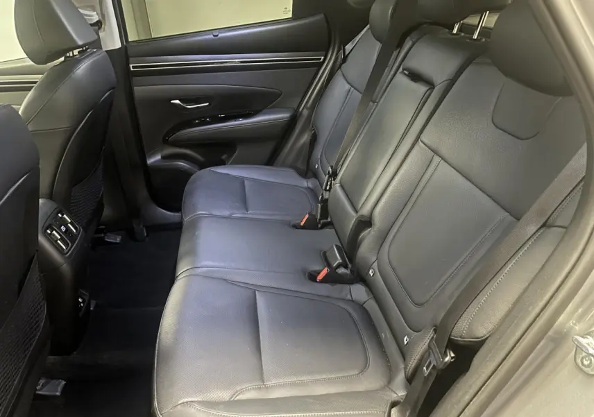 Vue latérale droite des sièges arrière en cuir noir du Hyundai Tucson 2023, soulignant l'espace et les ceintures de sécurité.