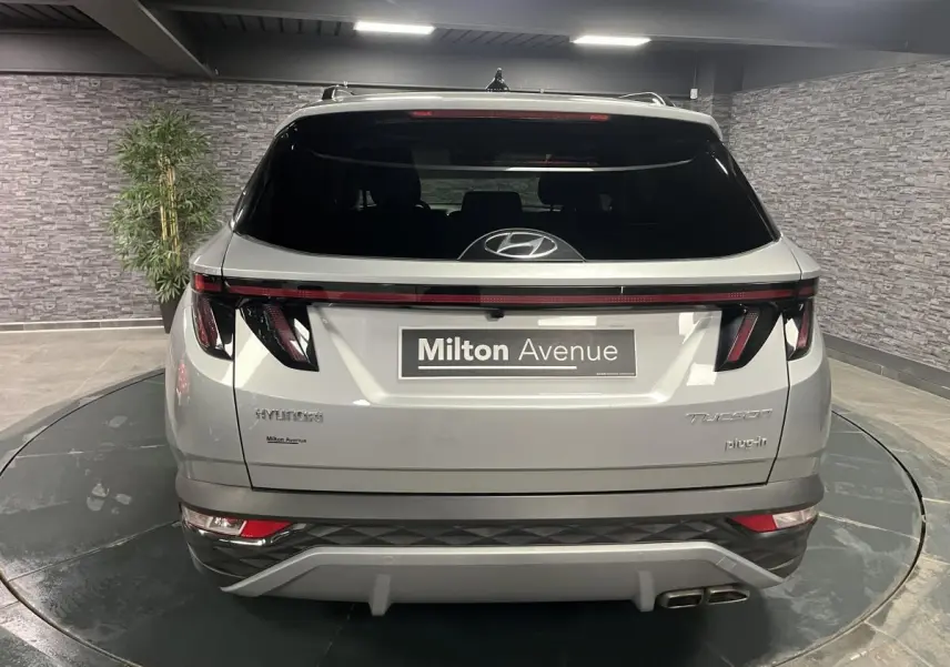 Vue arrière du Hyundai Tucson gris métallisé 2023 avec feux LED reliés et double sortie d’échappement visible.