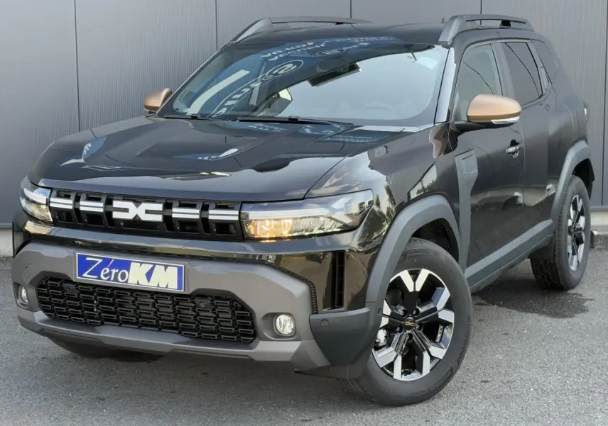 Vue 3/4 avant droite d'un Dacia Duster 2025 noir nacré avec coques de rétroviseur cuivrées et jantes alliage 17 pouces.