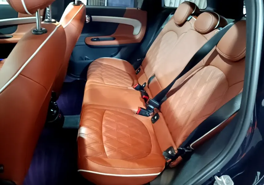 Vue intérieure côté droit des sièges arrière en cuir marron matelassé du MINI Countryman Cooper SE bleu 2021.