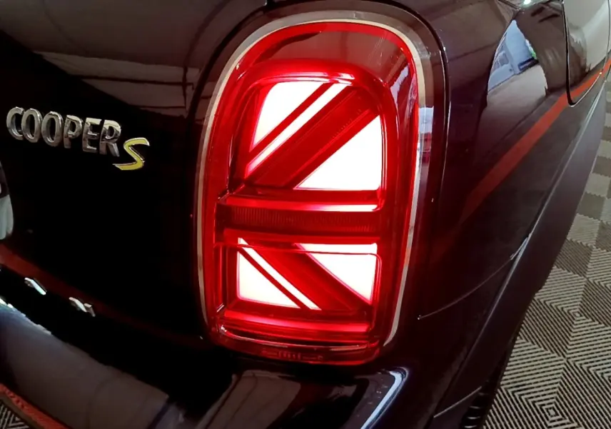 Gros plan sur le feu arrière droit rouge et le logo Cooper S sur la carrosserie bleu foncé d'une MINI Countryman.