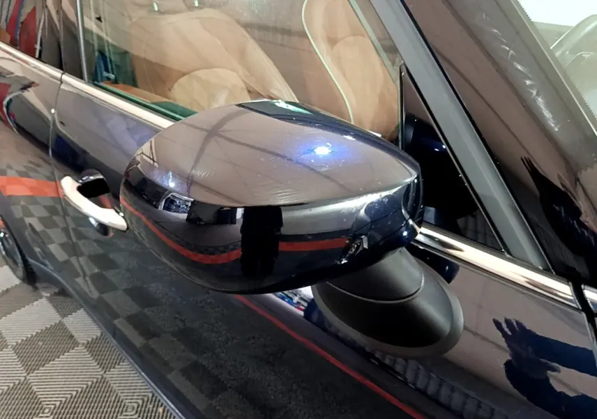 Rétroviseur côté gauche bleu brillant d'une MINI Countryman Cooper SE 2021 avec poignée de porte visible.