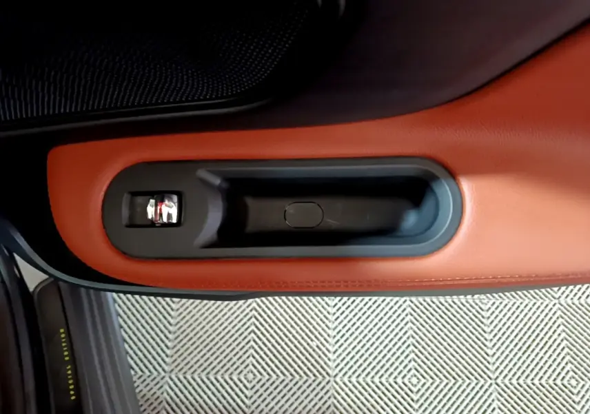 Poignée intérieure de porte en cuir marron avec bouton chrome sur MINI Countryman Cooper SE 2021.