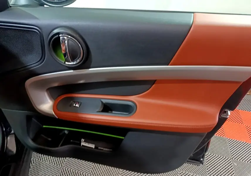 Gros plan sur la porte côté gauche du MINI Countryman 2021, avec garniture cuir marron et détails chromés.