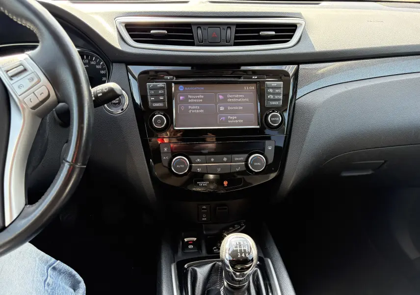 Vue intérieure centrée sur la console centrale et levier de vitesse manuel du Nissan X-TRAIL 2016, finition White Edition.