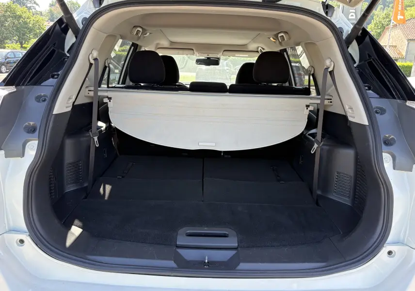 Coffre ouvert vu de l'arrière d'un Nissan X-TRAIL 1.6 DCI 130 White Edition 7 places blanc avec banquette arrière rabattue.