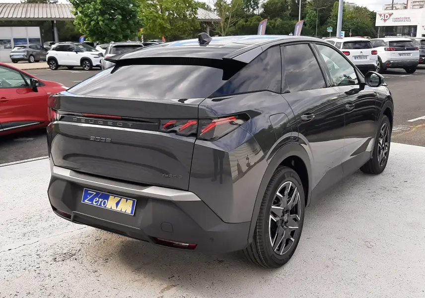 Vue 3/4 arrière droite d’un Peugeot 3008 gris titane 2026 avec feux arrière LED et toit noir brillant.