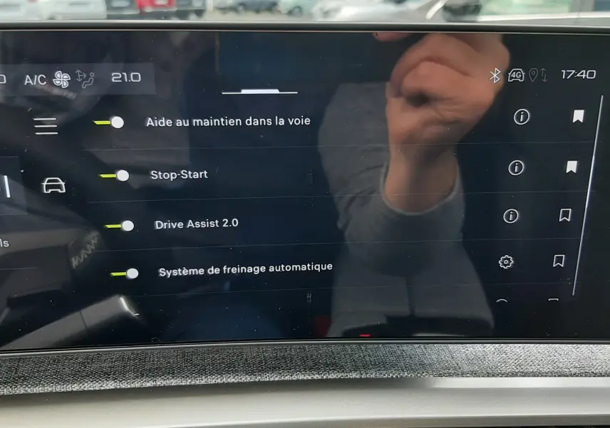Écran tactile intérieur du Peugeot 3008 gris titane 2026 affichant les aides à la conduite et la climatisation à 21°C.