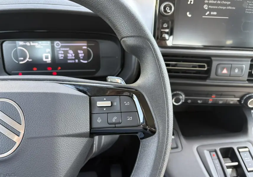 Vue rapprochée du volant multifonction et du tableau de bord numérique du Citroën Berlingo ë-136 2025, intérieur noir.