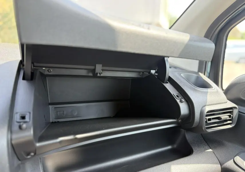 Vue rapprochée de la boîte à gants ouverte côté passager dans l’habitacle du Citroën Berlingo ë-136 bleu Kiama.