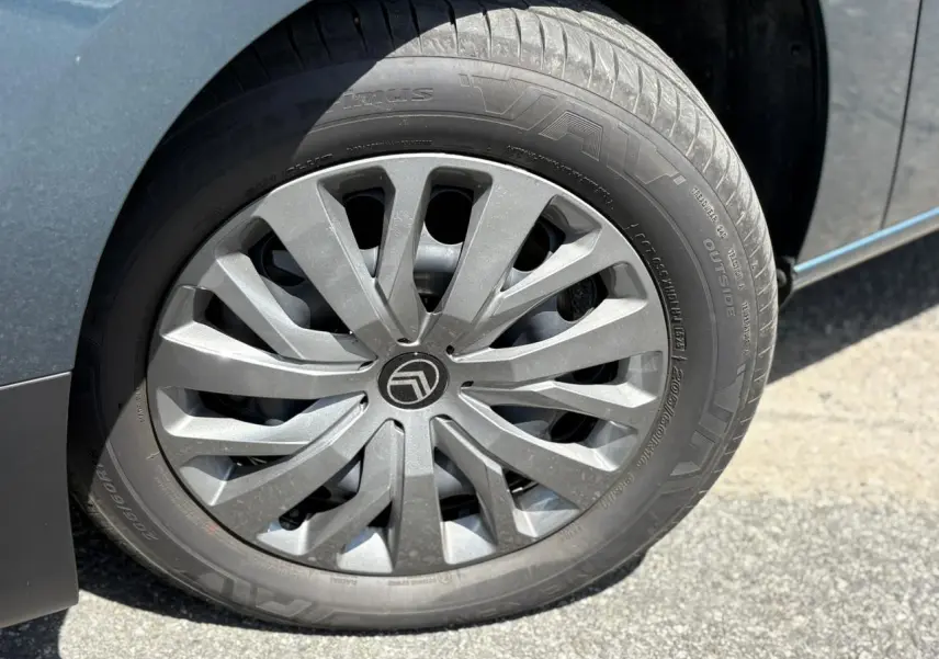 Gros plan sur la jante tôlée 16 pouces avec enjoliveur gris du côté avant droit du Citroën Berlingo Bleu Kiama.