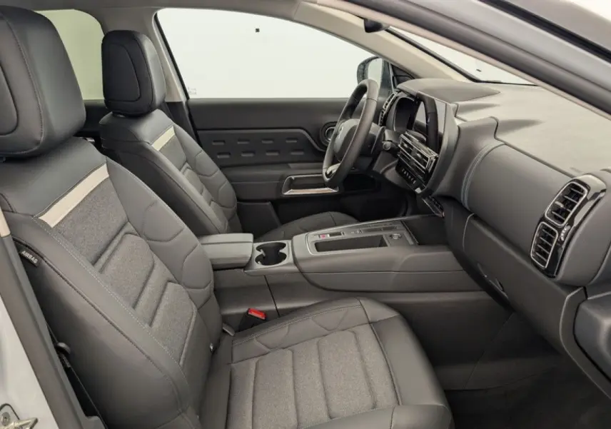 Vue intérieure côté conducteur du Citroën C5 Aircross blanc Okenite, sièges en cuir et tissu gris avec tableau de bord moderne.