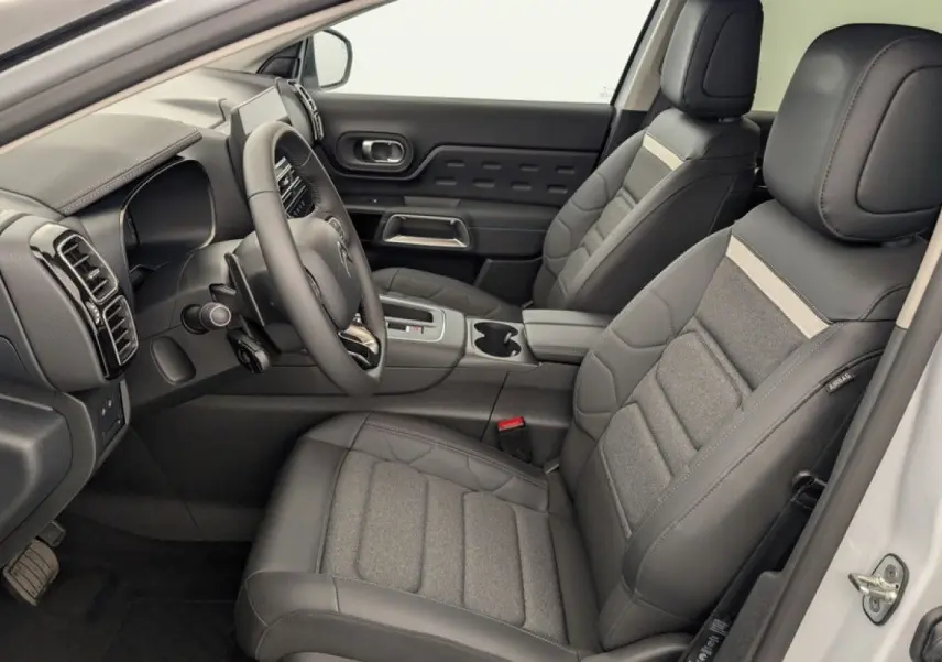 Intérieur avant droit du Citroën C5 Aircross blanc Okenite 2025, sièges en cuir et tissu gris avec console centrale moderne.