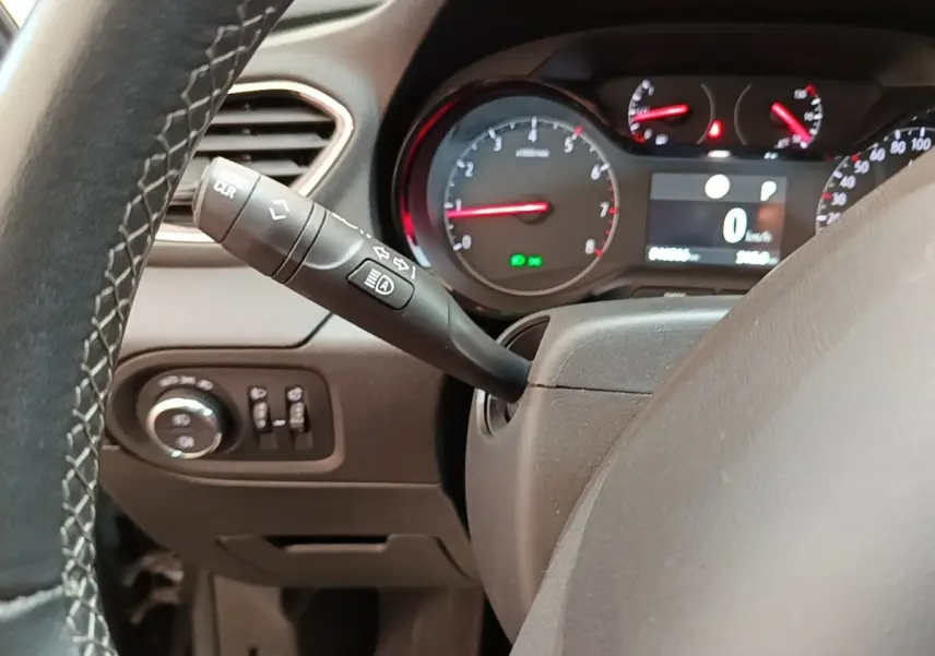 Vue rapprochée du tableau de bord et du volant cuir alu d’un Opel Grandland X gris foncé, avec commandes et compteurs visibles.