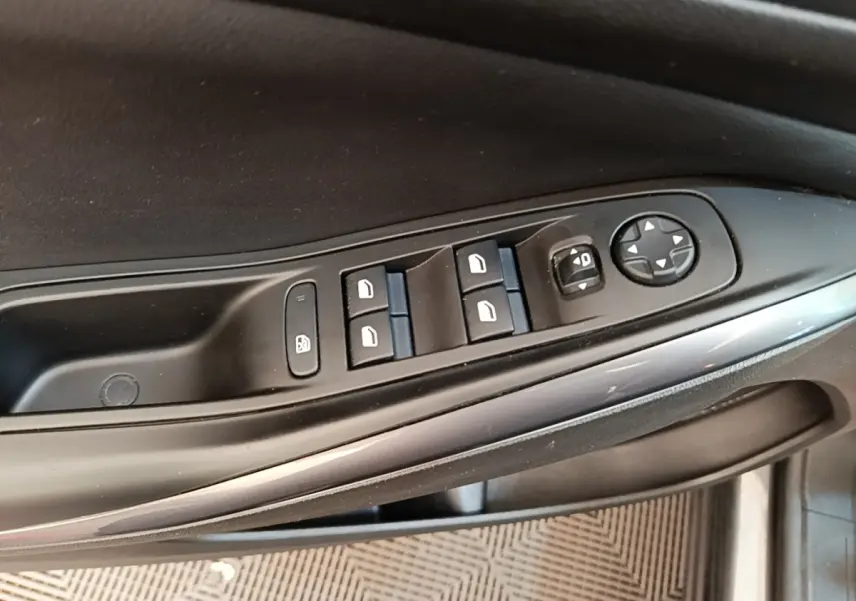 Gros plan sur les commandes de lève-vitres et rétroviseurs côté conducteur de l'Opel Grandland X gris foncé.