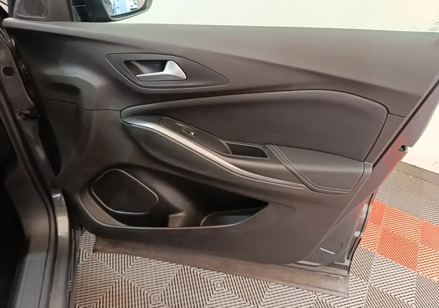 Vue intérieure du panneau de porte côté conducteur de l’Opel Grandland X gris foncé, avec poignée alu et commandes vitres.