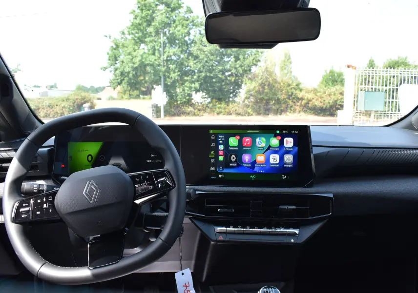 Vue intérieure avant de la Renault Clio VI TCE 115 gris schiste, avec tableau de bord numérique et écran tactile central.