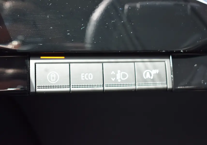 Gros plan sur les boutons de commande gris du tableau de bord de la Renault Clio VI TCe 115 Evolution+ 2026.