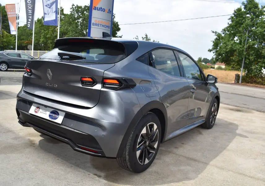 Renault Clio VI gris schiste vue 3/4 arrière droit, avec feux LED et jantes alliage distinctives.