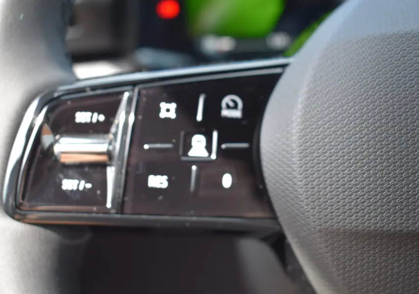 Gros plan sur les commandes au volant de la Renault Clio VI TCe 115 Evolution+ avec finition noire brillante.