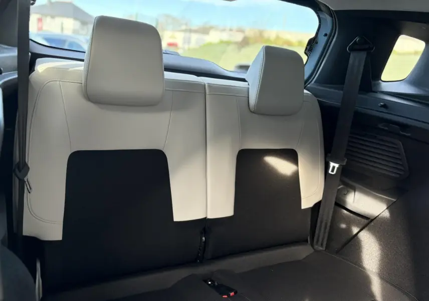 Vue arrière intérieure sur la banquette 2 places arrière bi-ton noir et gris clair du Citroën C3 Aircross Hybrid 2025.