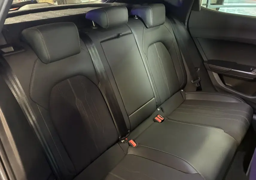 Vue intérieure des sièges arrière noirs du CUPRA Formentor 1.4 e-Hybrid 2023, avec appuie-têtes et ceintures visibles.