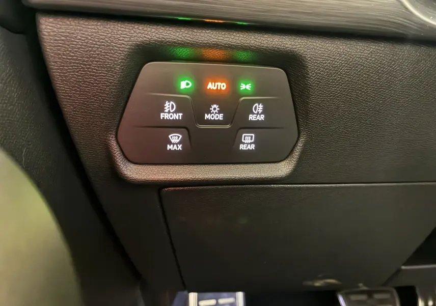 Gros plan sur les commandes d’éclairage et désembuage du tableau de bord noir du CUPRA Formentor gris 2023.