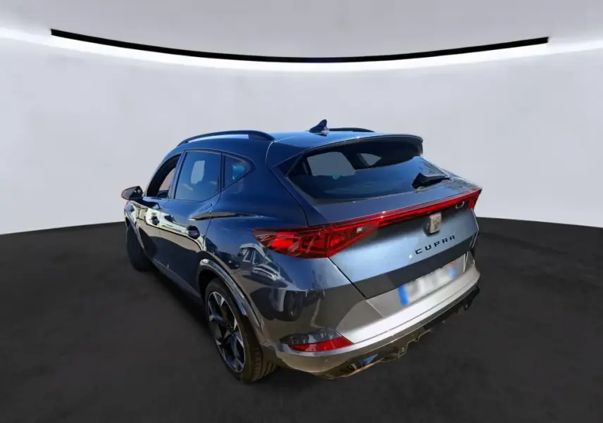 Vue 3/4 arrière droite d'un SUV CUPRA Formentor gris avec feux arrière LED et toit avec antenne requin.