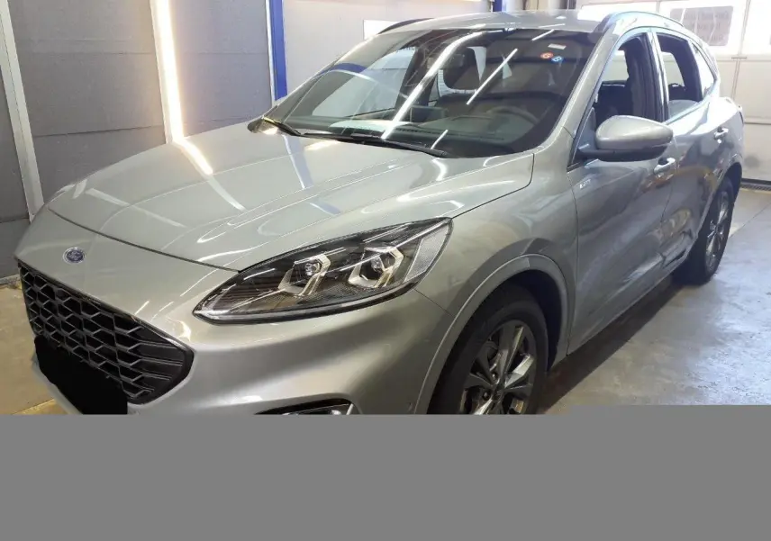 Vue 3/4 avant droite du Ford Kuga 2024 gris Solar avec calandre noire et phares Full LED visibles en intérieur.