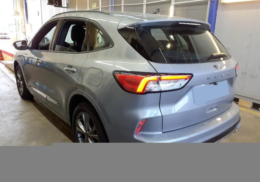 Vue 3/4 arrière droite du Ford Kuga gris Solar 2024 avec feux LED allumés et jantes alliage 18 pouces.