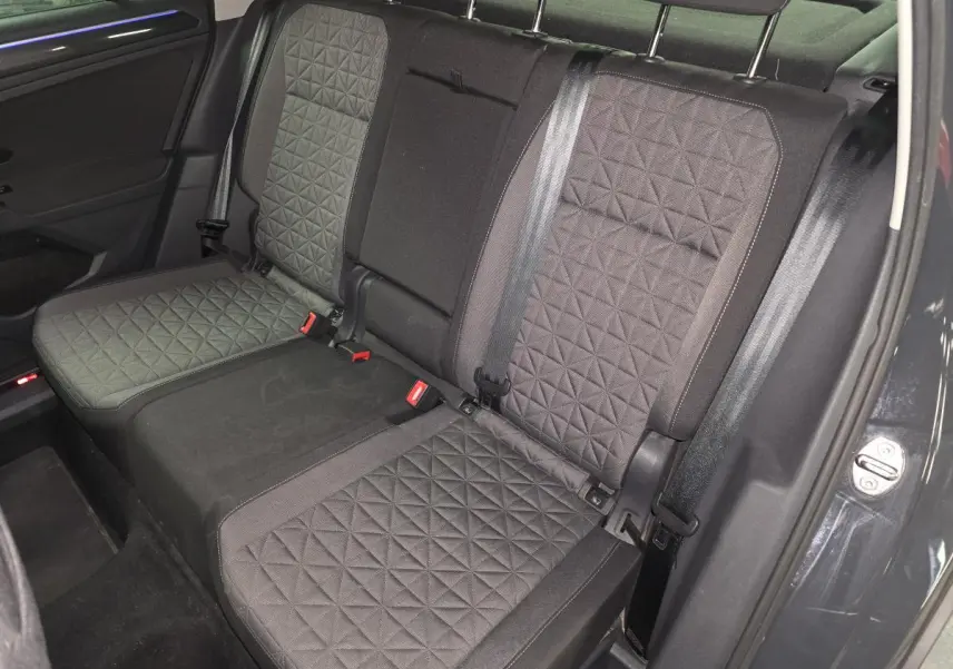 Vue intérieure sur la banquette arrière du Volkswagen Tiguan 2022, tissu gris à motif géométrique, ceinture noire visible.