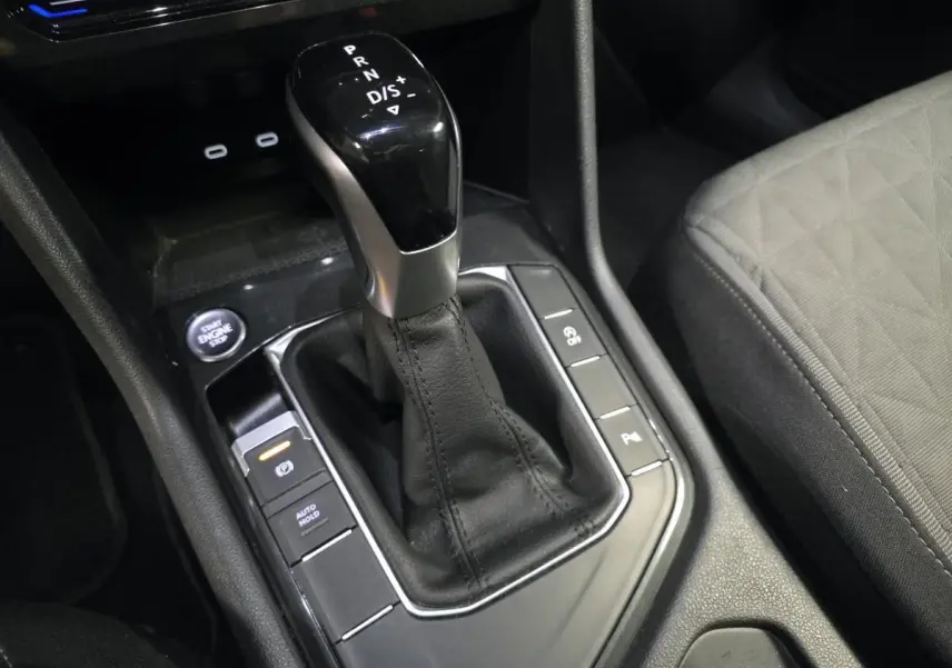 Gros plan sur la console centrale du Volkswagen Tiguan 2022, levier de boîte auto noir et siège tissu gris visible.