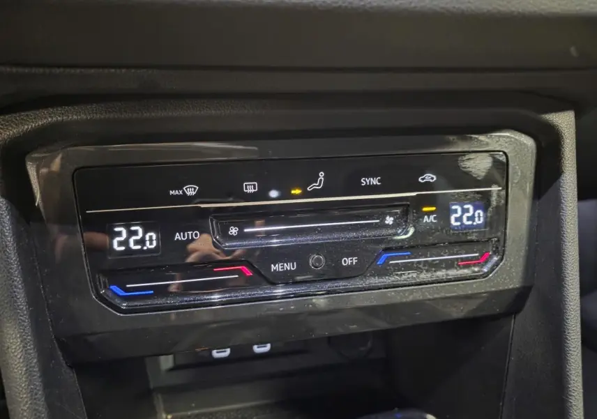 Gros plan sur la commande de climatisation automatique tri-zone du Volkswagen Tiguan gris, affichant 22°C.