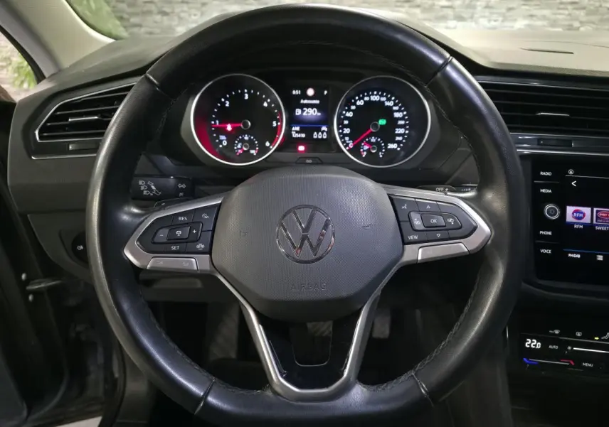 Vue rapprochée du volant cuir multifonctions noir et du tableau de bord digital du Volkswagen Tiguan gris 2022.