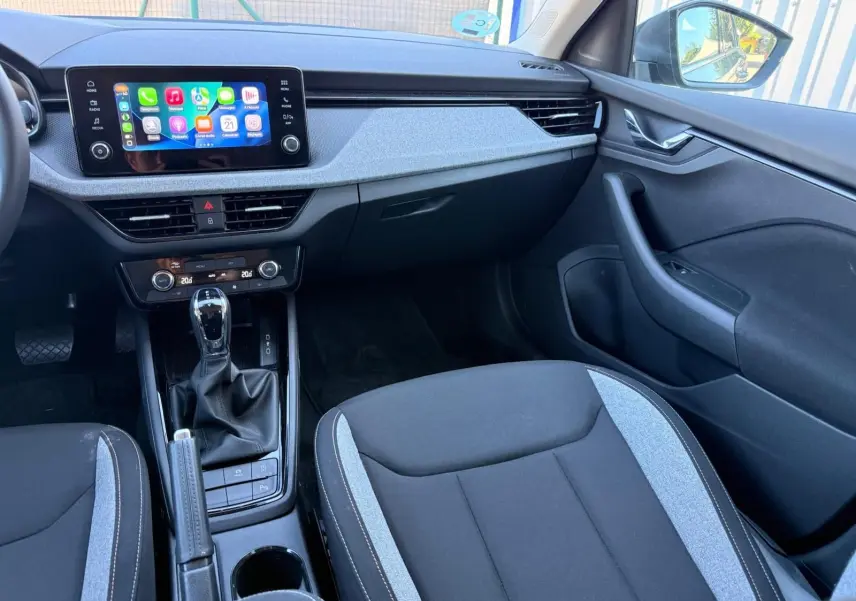 Vue intérieure côté passager de la Skoda Scala 2025, avec sellerie noire et grise et écran tactile central lumineux.