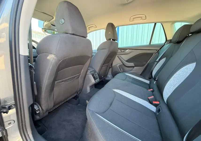 Vue intérieure arrière côté gauche de la Skoda Scala 2025 gris graphite, montrant les sièges tissu bicolores et les aérateurs centraux.